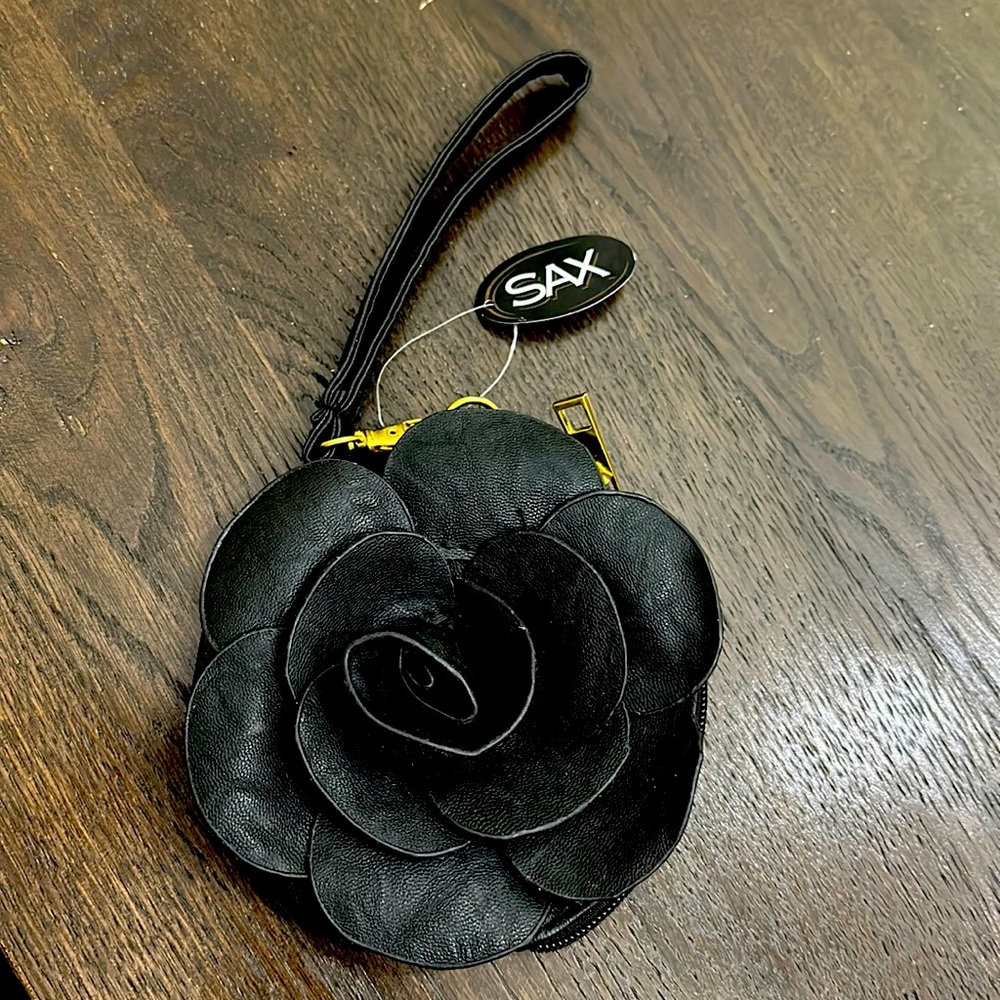 Small black evening purse. Small. Design on front is a flower. Dressy.